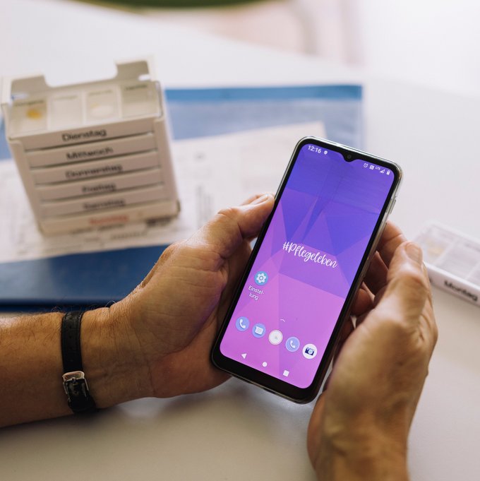 Hände einer älteren Dame halten ein Smartphone
