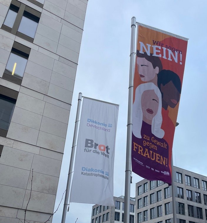 Eine Fahne mit der Aufschrift "Nein zu Gewalt gegen Frauen" hängt vor dem Gebäude des Evangelischen Werks für Diakonie und Entwicklung.