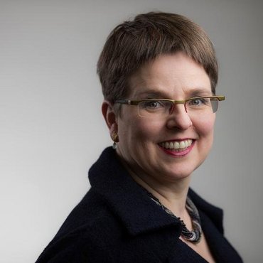 Eine Frau mit Brille lächelt in die Kamera