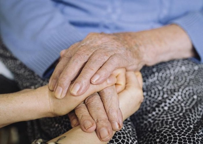 Eine ältere Hand und eine junge Hand liegen übereinander