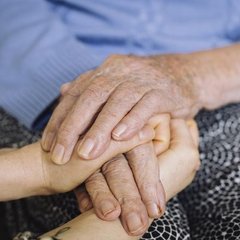 Eine ältere Hand und eine junge Hand liegen übereinander